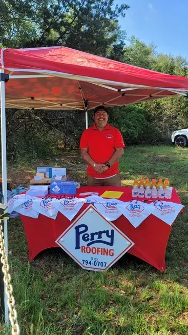A man is standing behind a table under a tent.