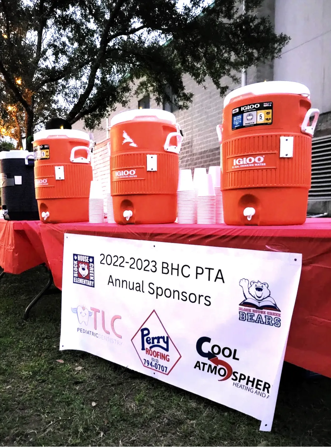 A table with coolers and a sign that says annual sponsors on it.