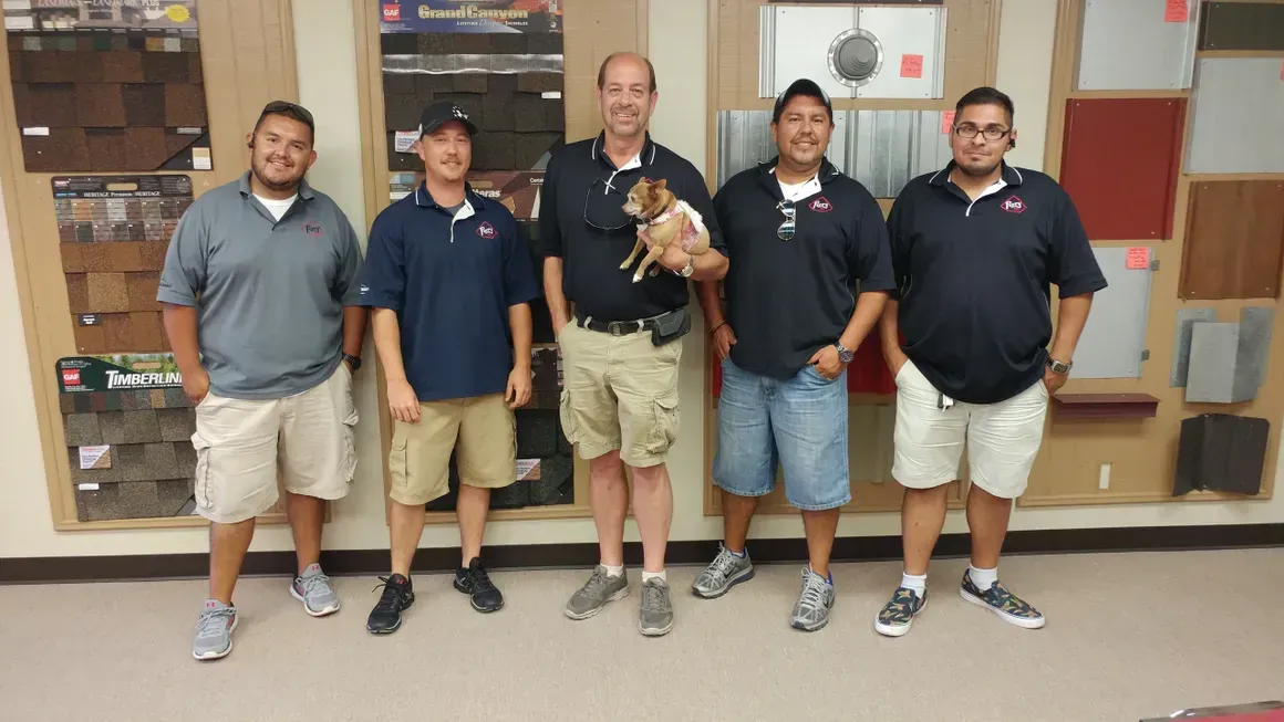 A group of men standing next to each other holding a small dog
