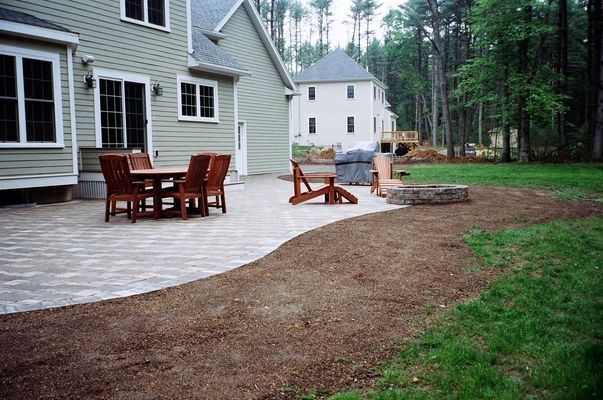 Backyard patio with dining set, edging a path of mulch through the lawn.