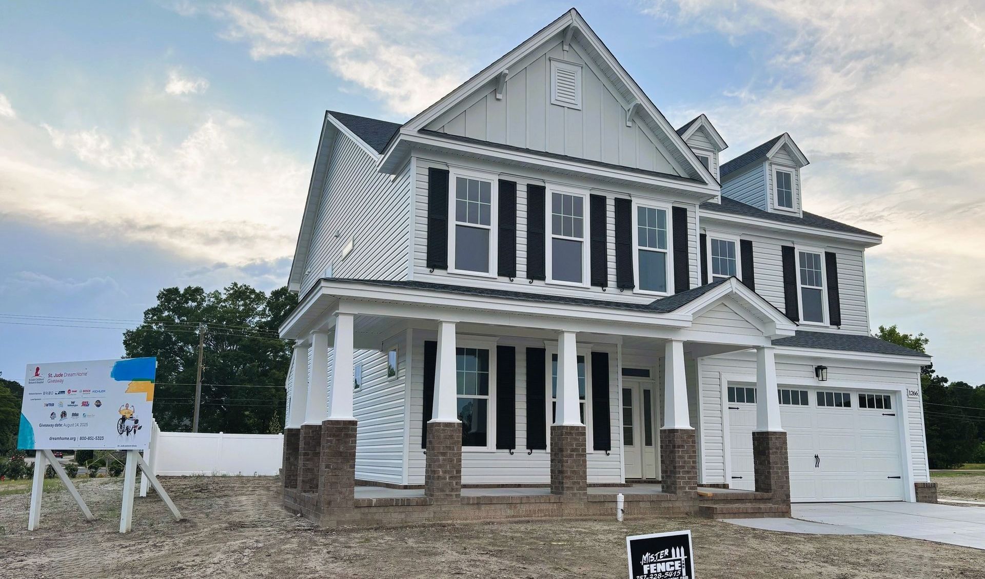 A house with a screened in porch and a black fence in front of it.