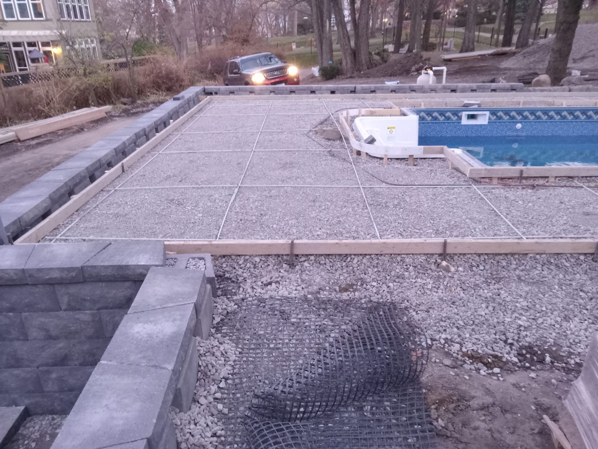 A truck is driving past a swimming pool under construction