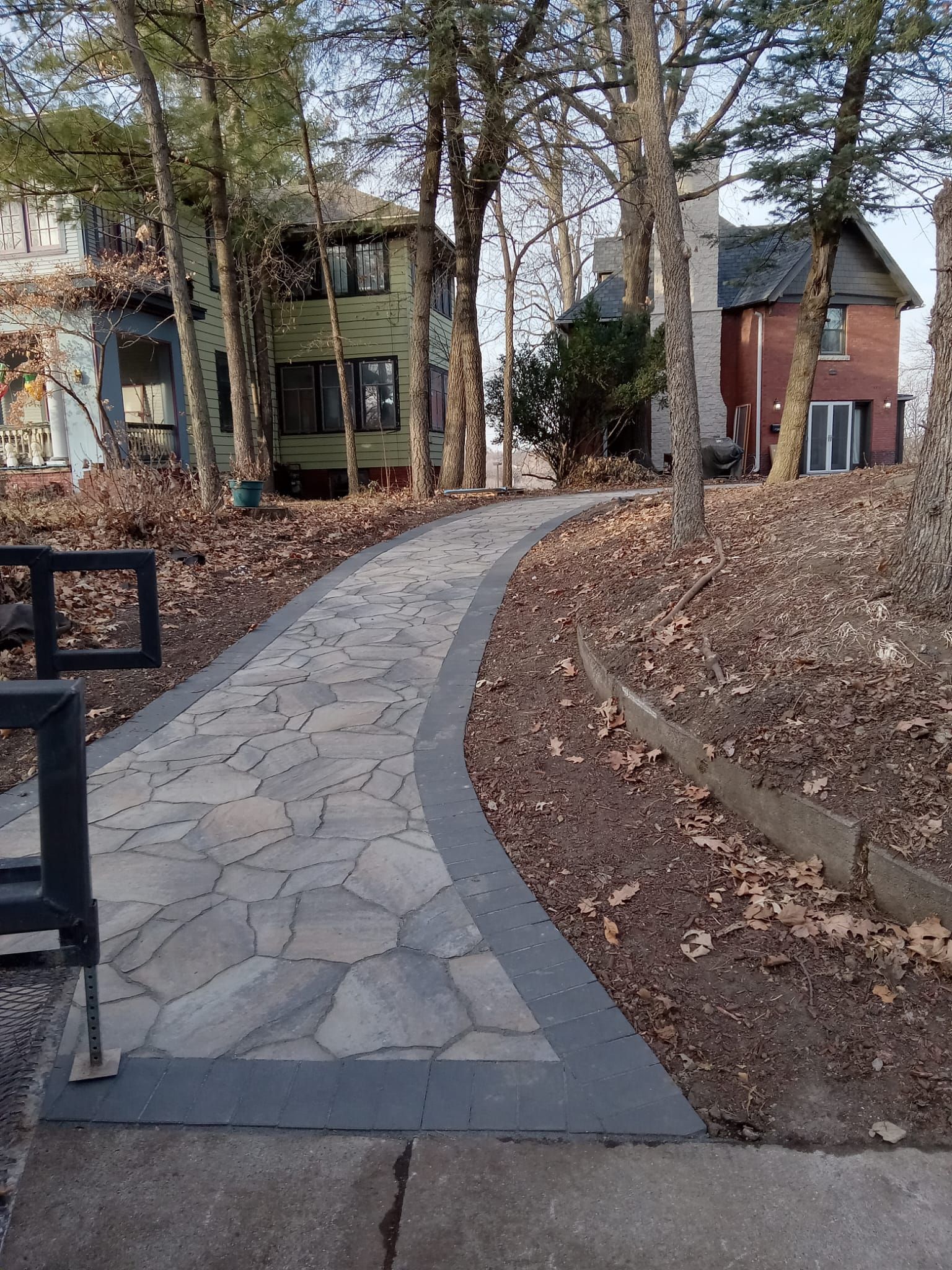 A stone walkway leading to a house in the woods