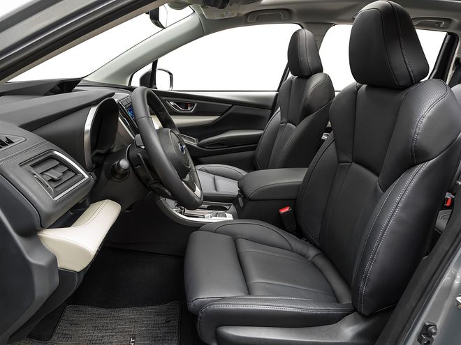 Car interior with black leather seats and steering wheel, viewed from the open driver’s side door