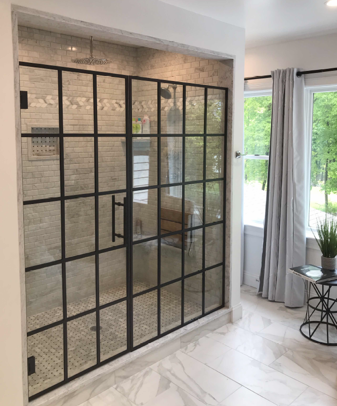 A bathroom with a walk in shower and a glass door.