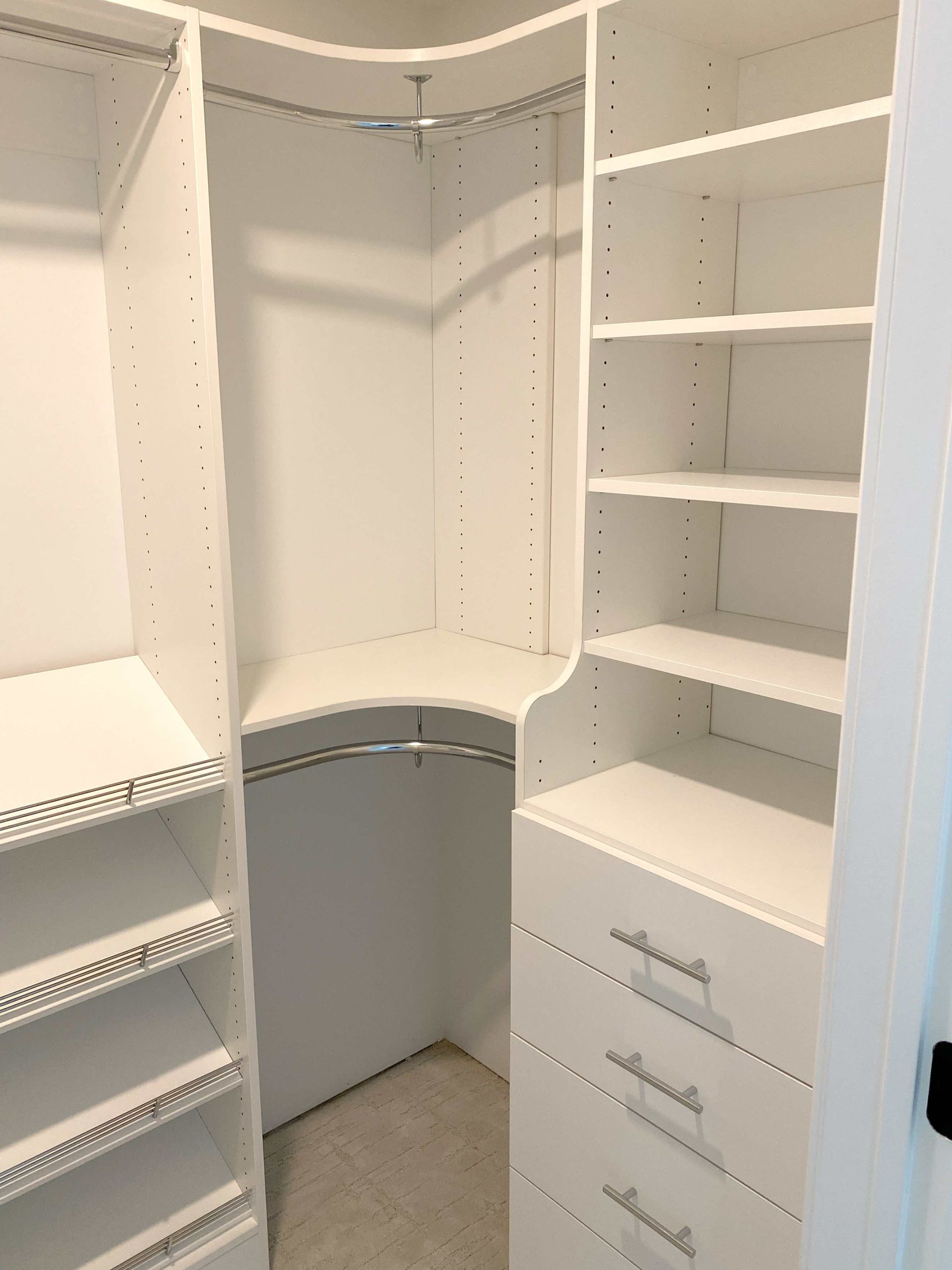 A walk in closet with lots of shelves and drawers.