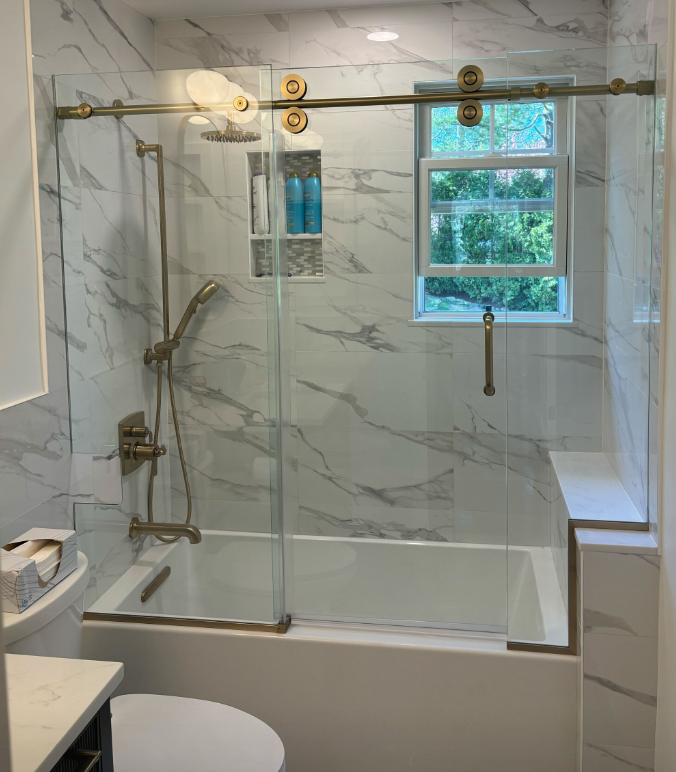 A bathroom with a sliding glass shower door.
