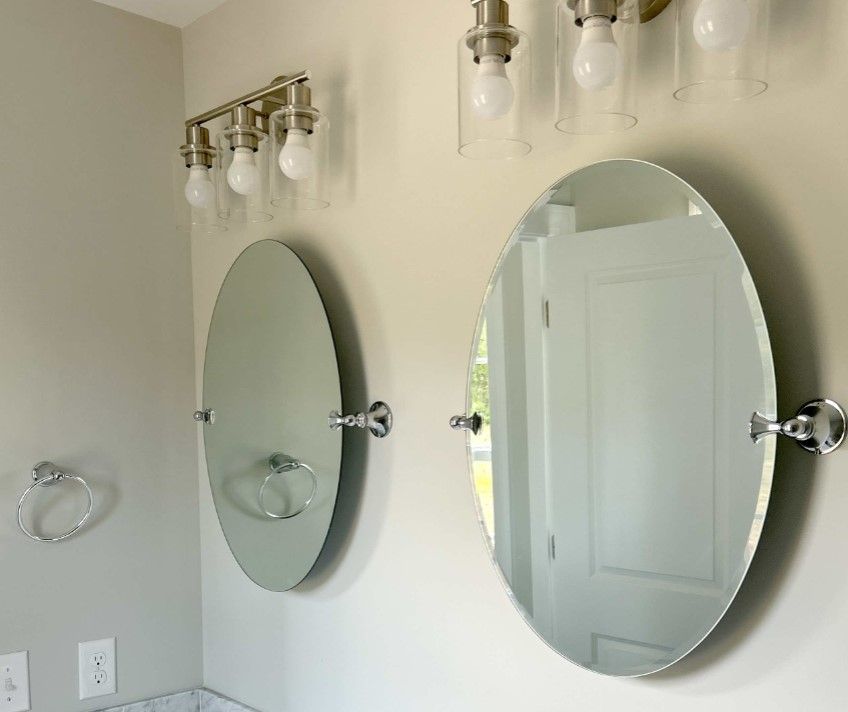 A bathroom with two round mirrors on the wall.
