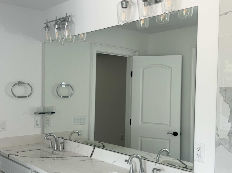 A bathroom with two sinks and a large mirror.