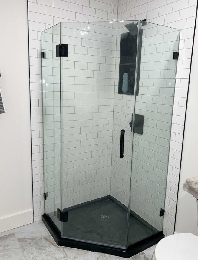 A bathroom with a shower stall and a toilet.
