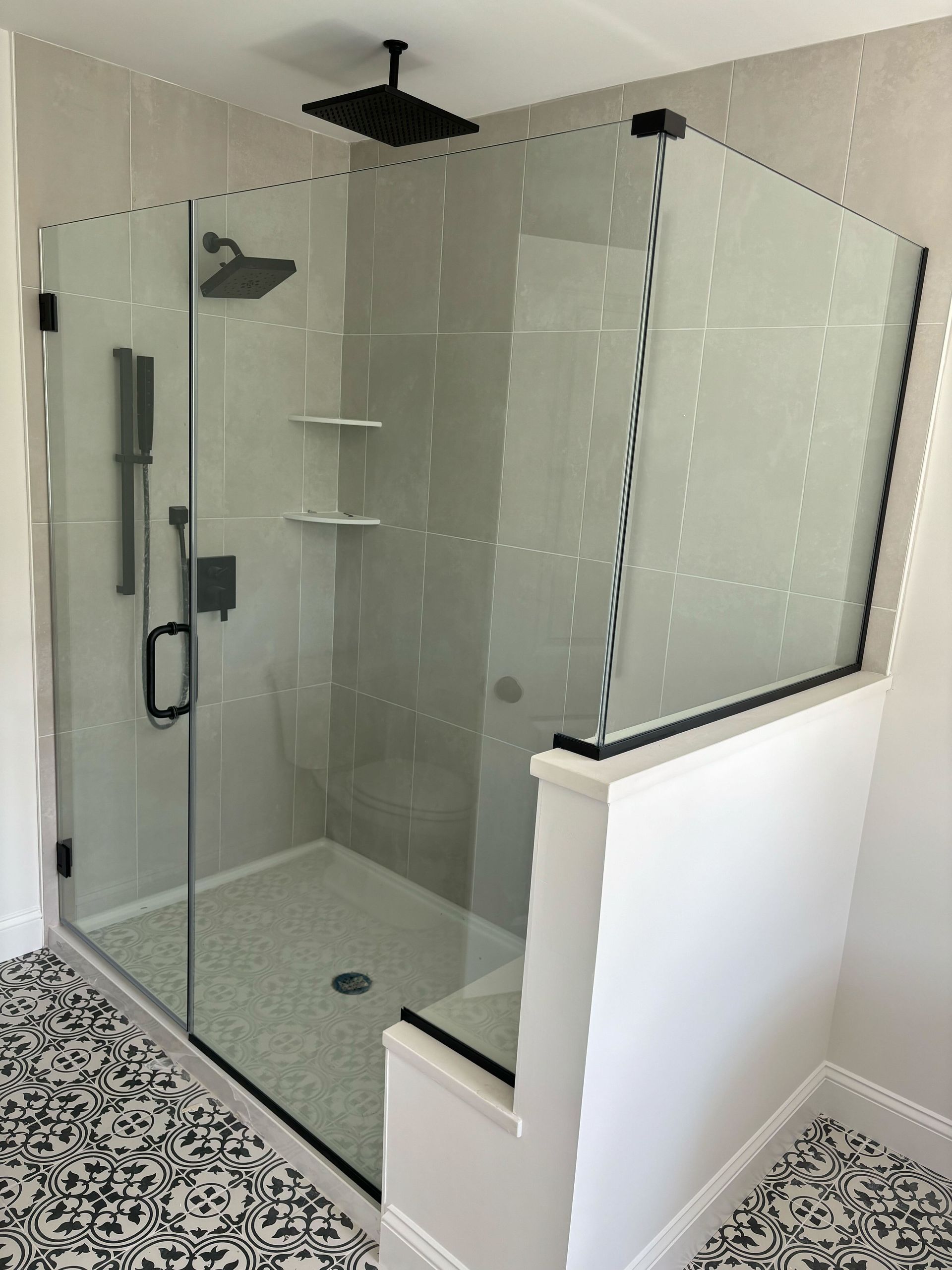 A bathroom with a walk in shower with a glass door