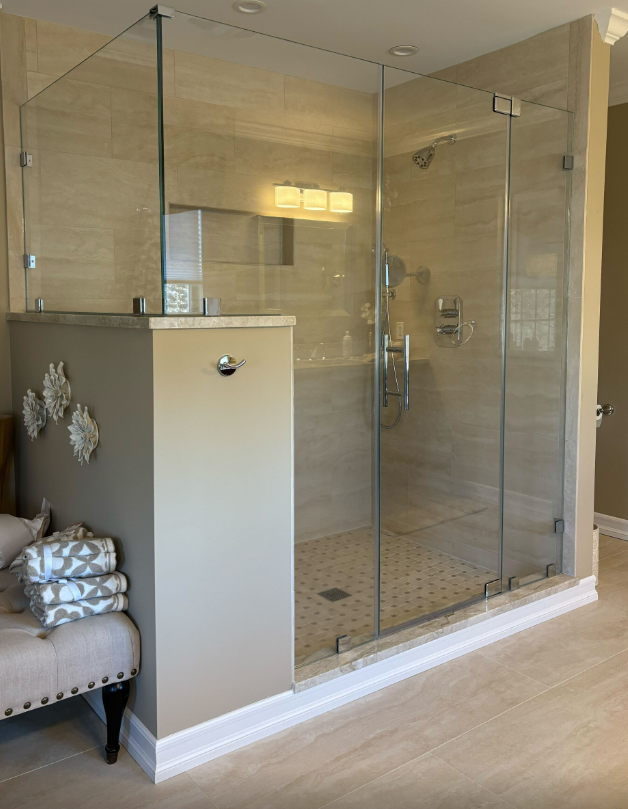 A bathroom with a walk in shower with a glass door.