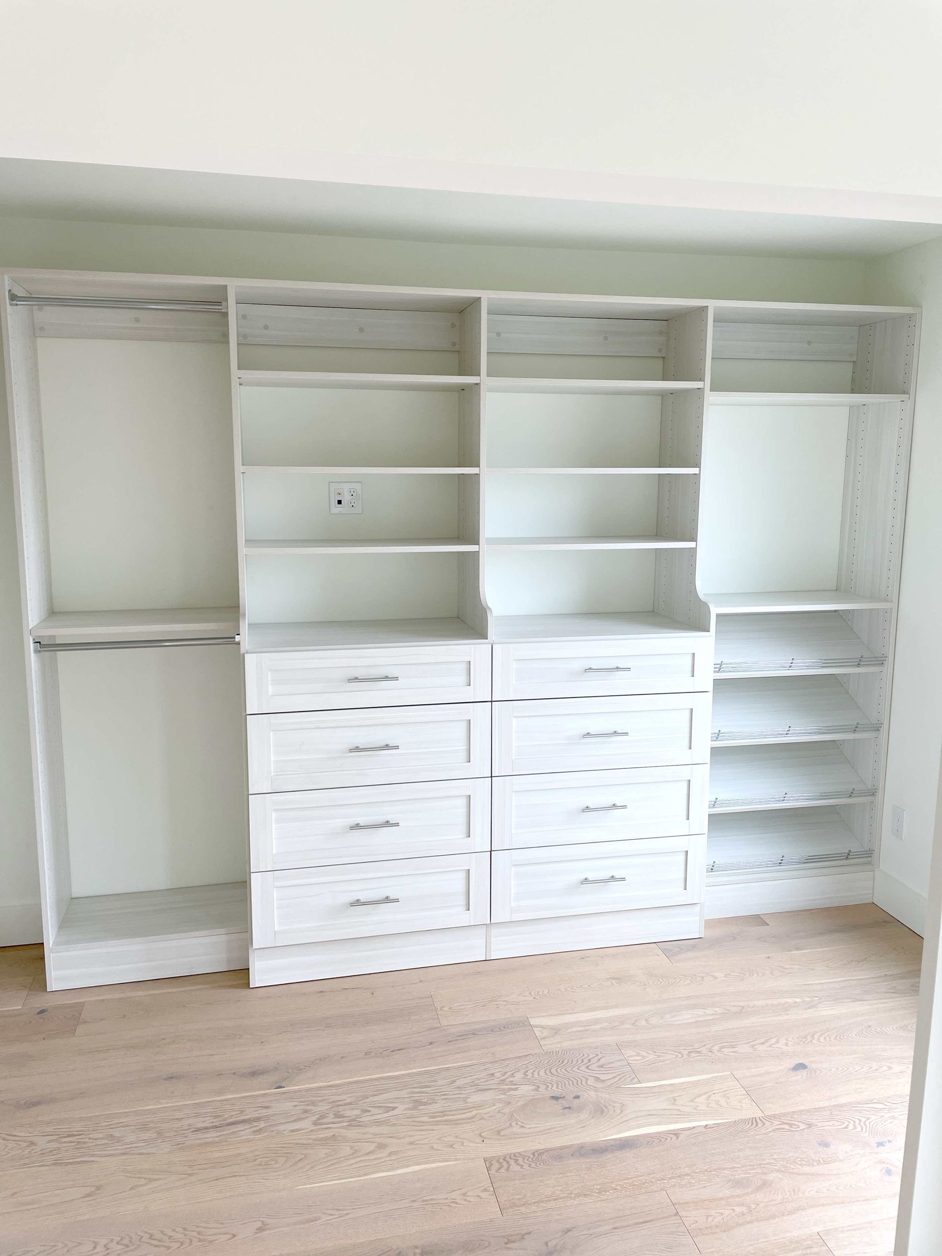 A large closet with lots of shelves and drawers in a room.