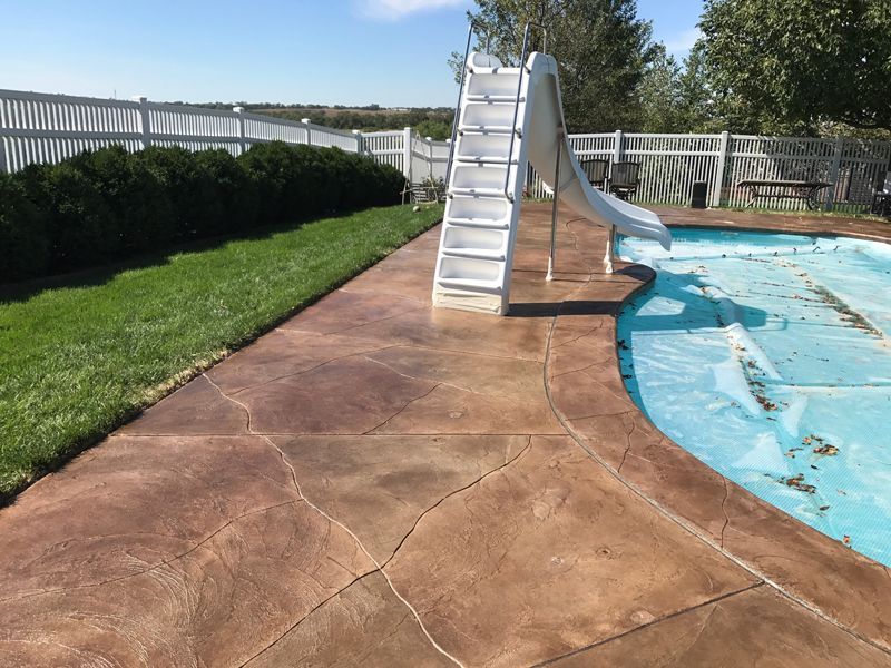 A swimming pool with a slide and stairs next to it