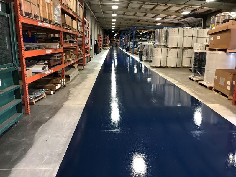 A large warehouse with lots of shelves and boxes on the floor.