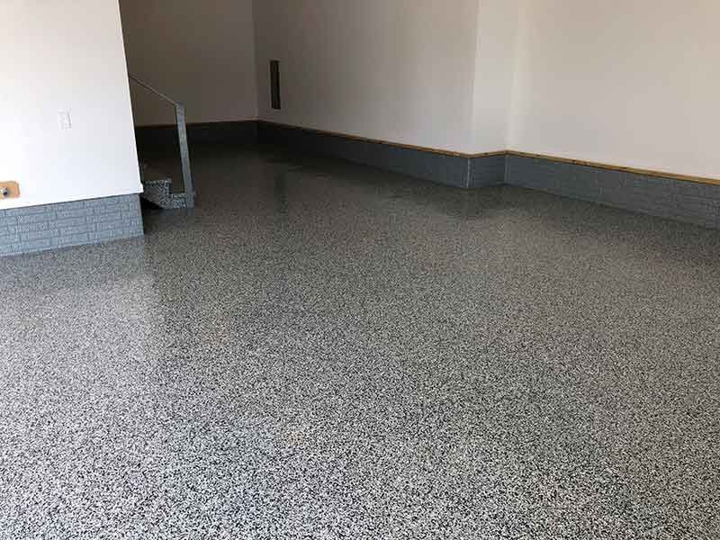 A garage with a gray floor and white walls.
