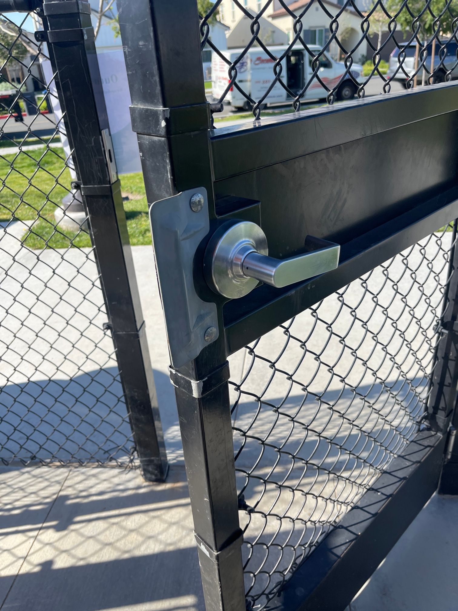 A close up of a chain link fence with a door handle.