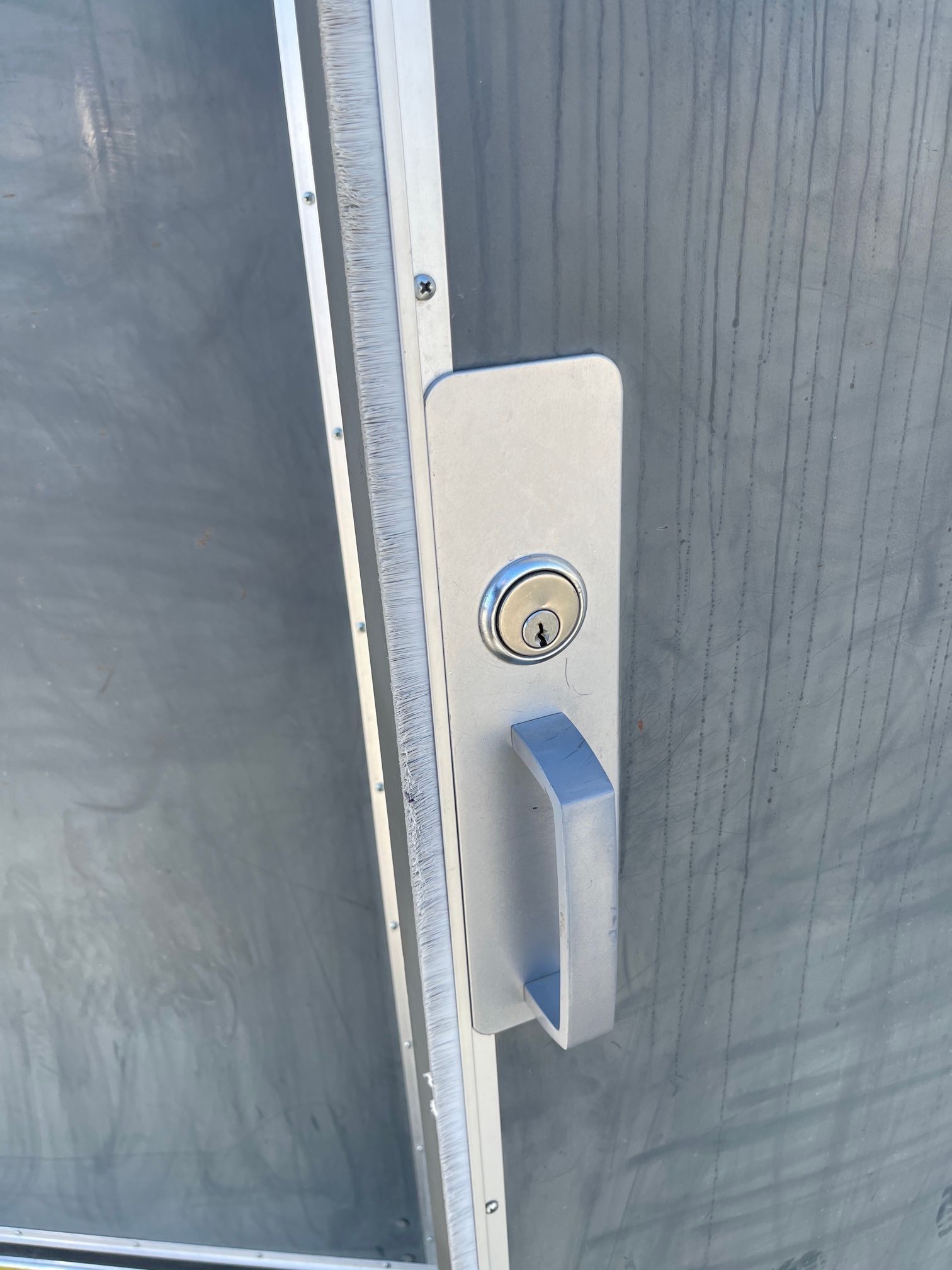 A stainless steel door handle with a key on it
