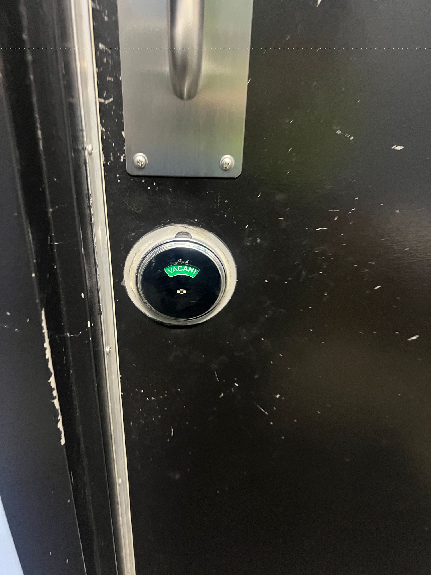 A close up of a door with a green light on it