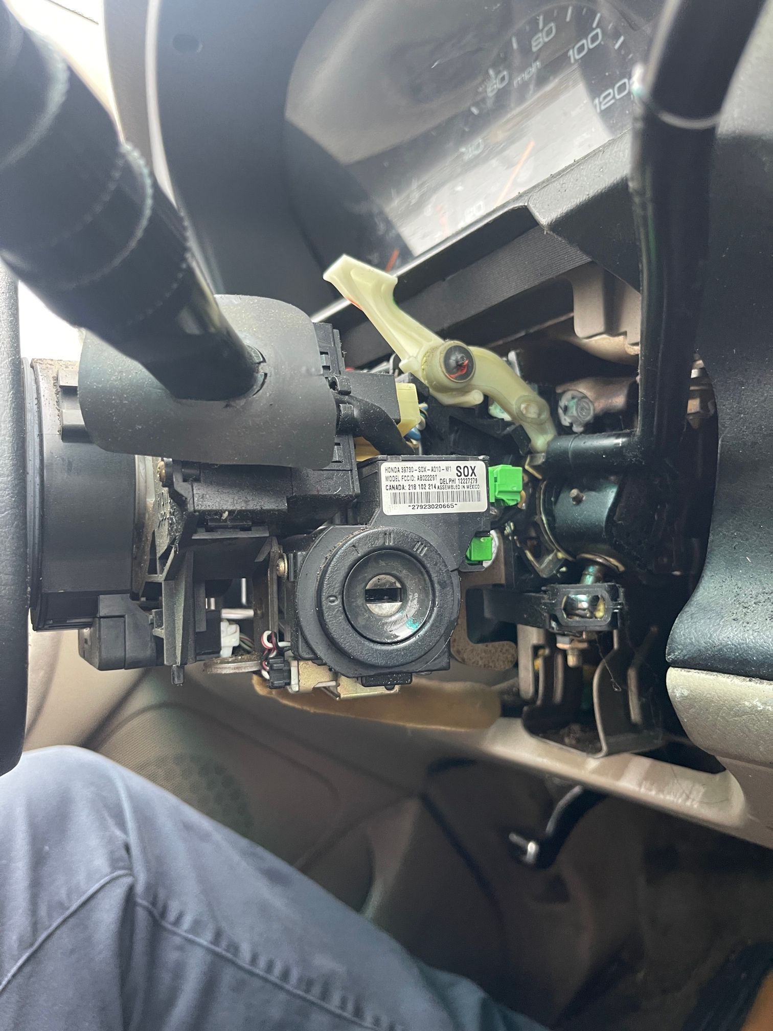A person is sitting in a car with the steering wheel removed.