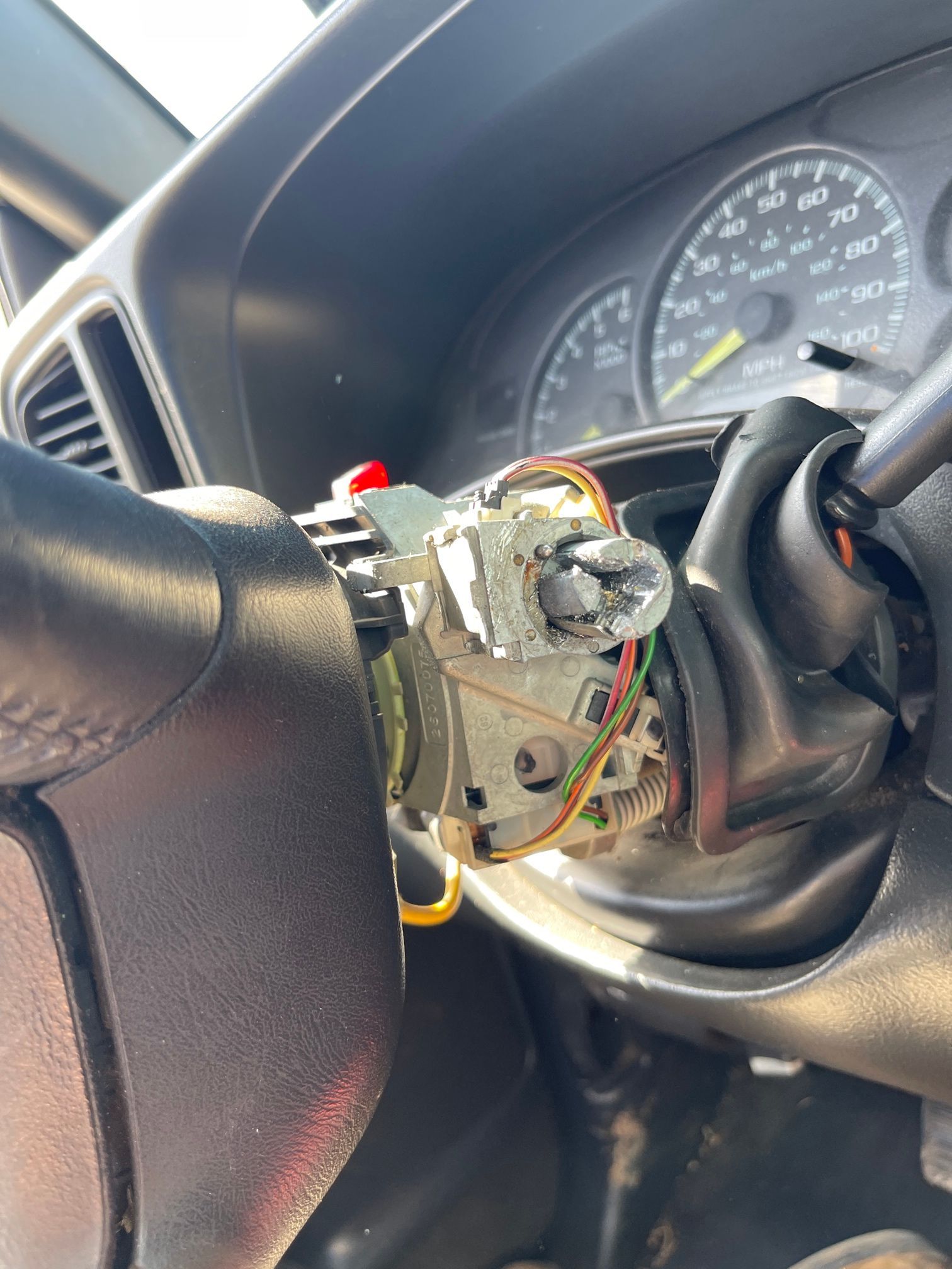 A close up of a car steering wheel with a key in it.