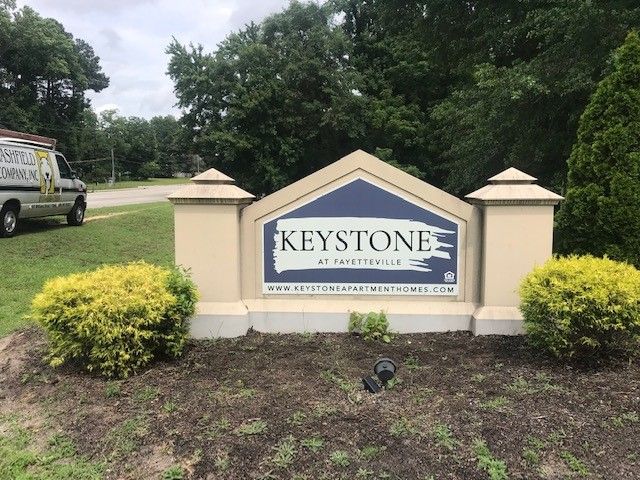 A sign that says keystone is in the middle of a field.