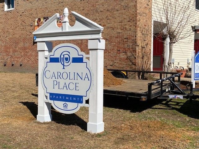 A carolina place sign in front of a brick building