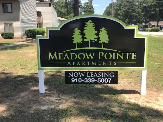 A sign that says meadow pointe apartments on it