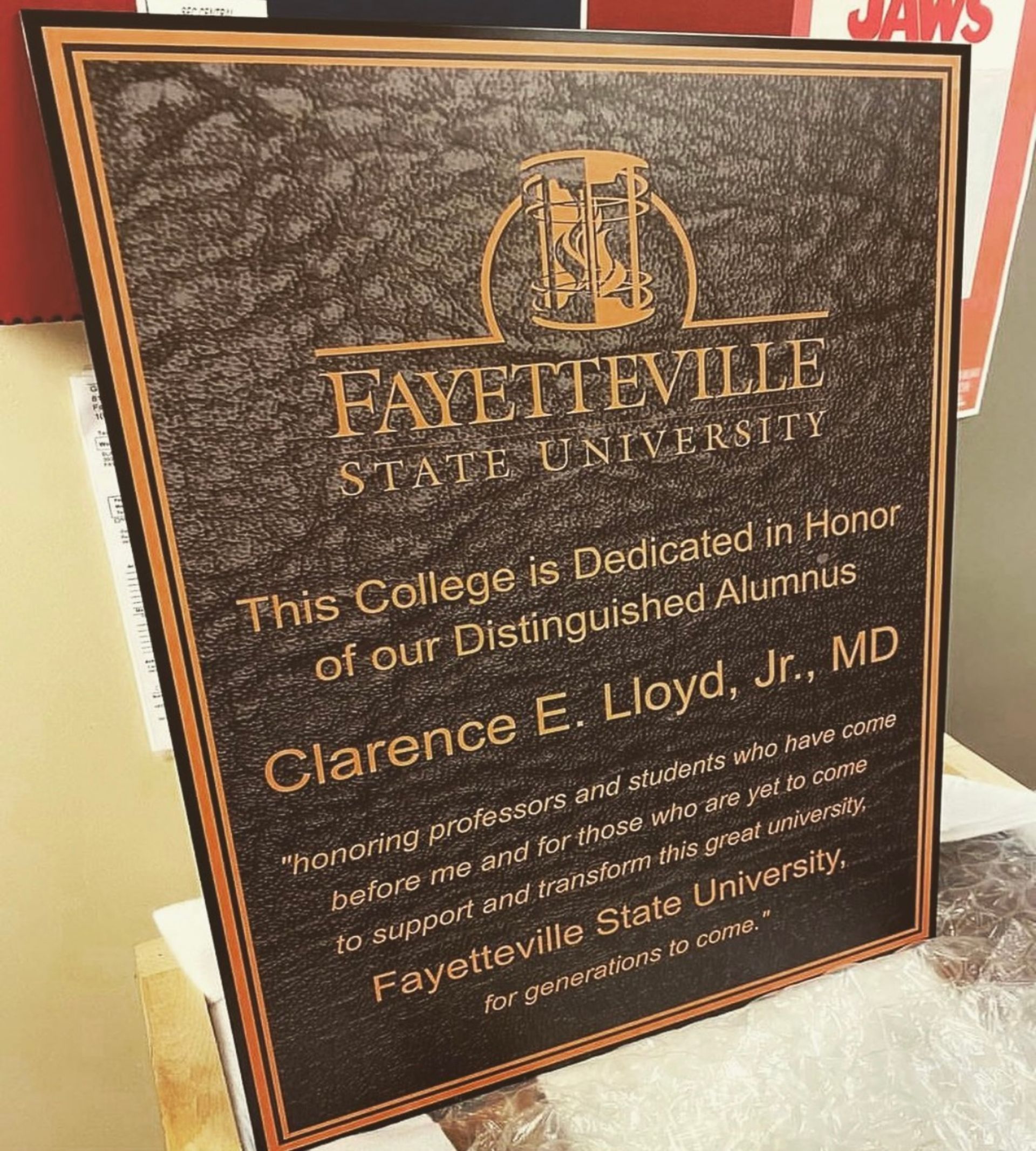 A plaque that says fayetteville state university is sitting on a table.