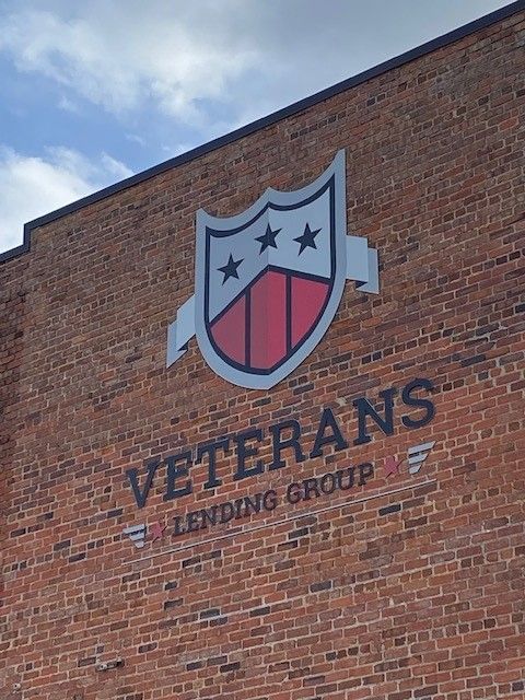A brick building with a veterans lending group logo on it