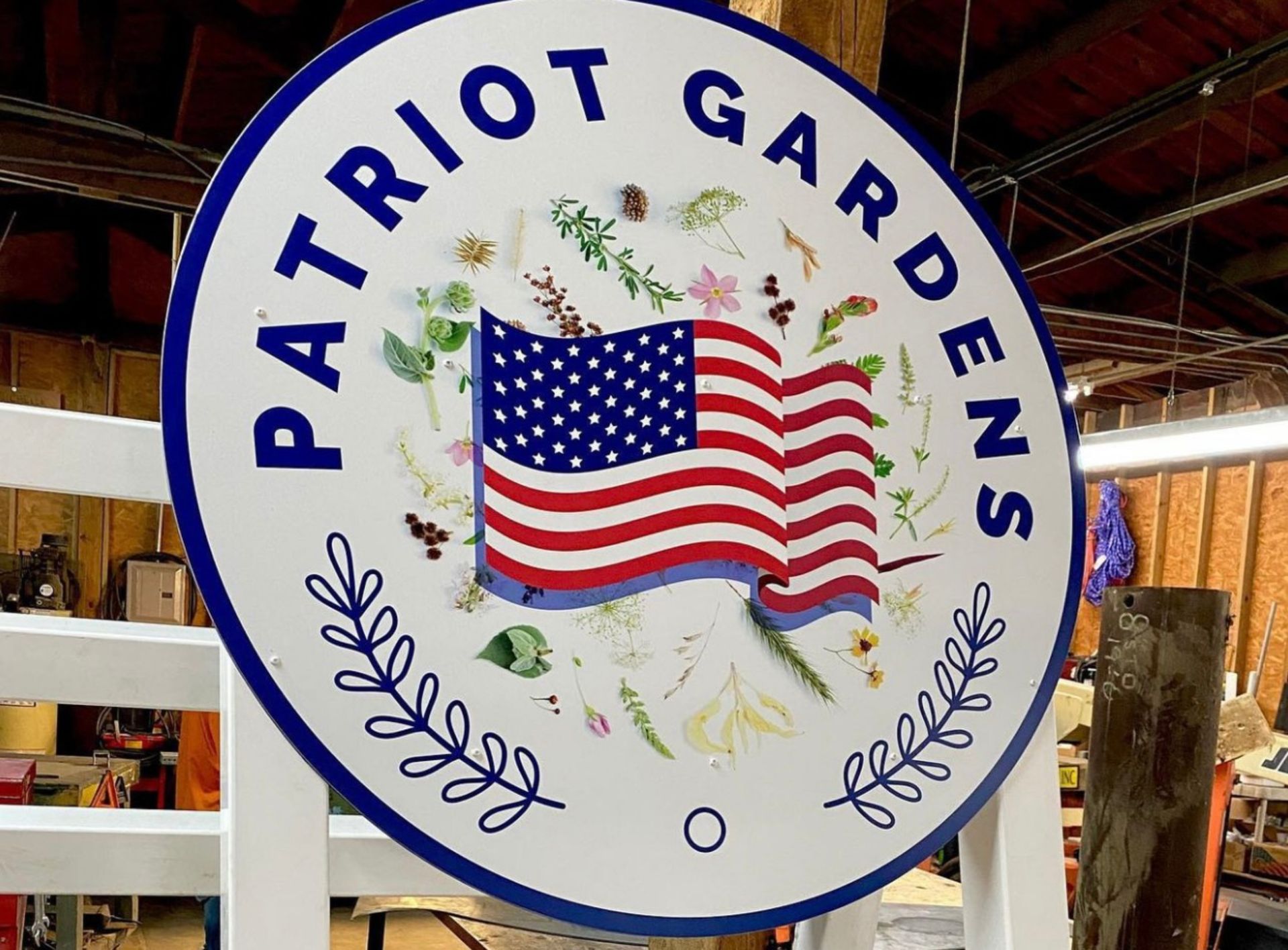 A patriot gardens sign with an american flag on it
