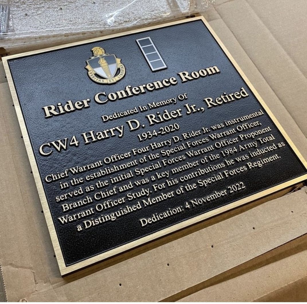A black and gold plaque is sitting on top of a cardboard box.