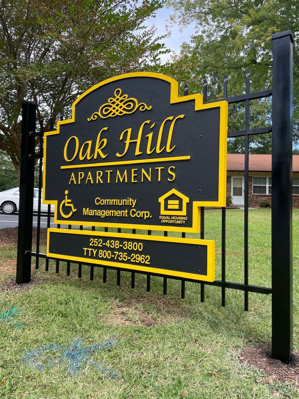 A black and yellow sign for oak hill apartments