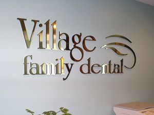 A sign on a wall that says village family dental