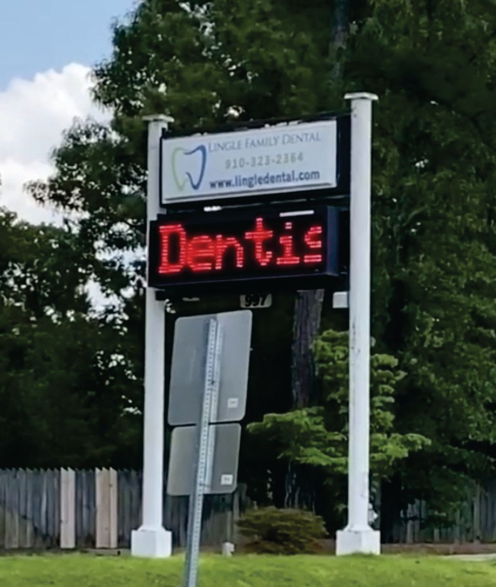 A sign that says dentis on it in red