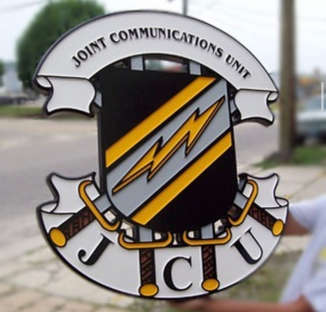 A person is holding a sign that says joint communications unit