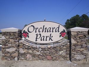 A stone wall with a sign that says orchard park