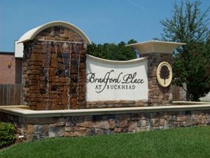 A sign for bradford place at buckhead with a waterfall