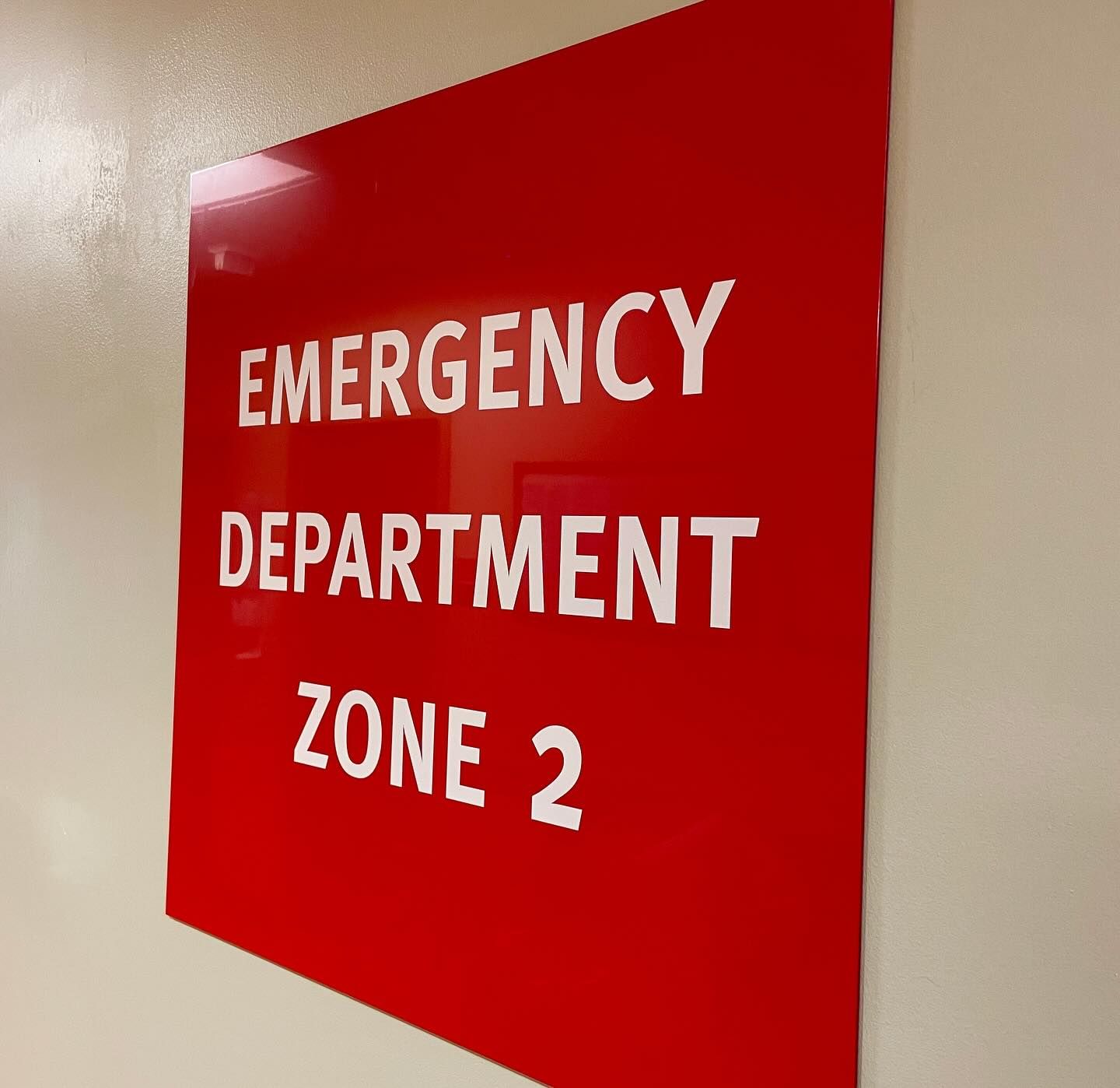 A red sign that says emergency department zone 2