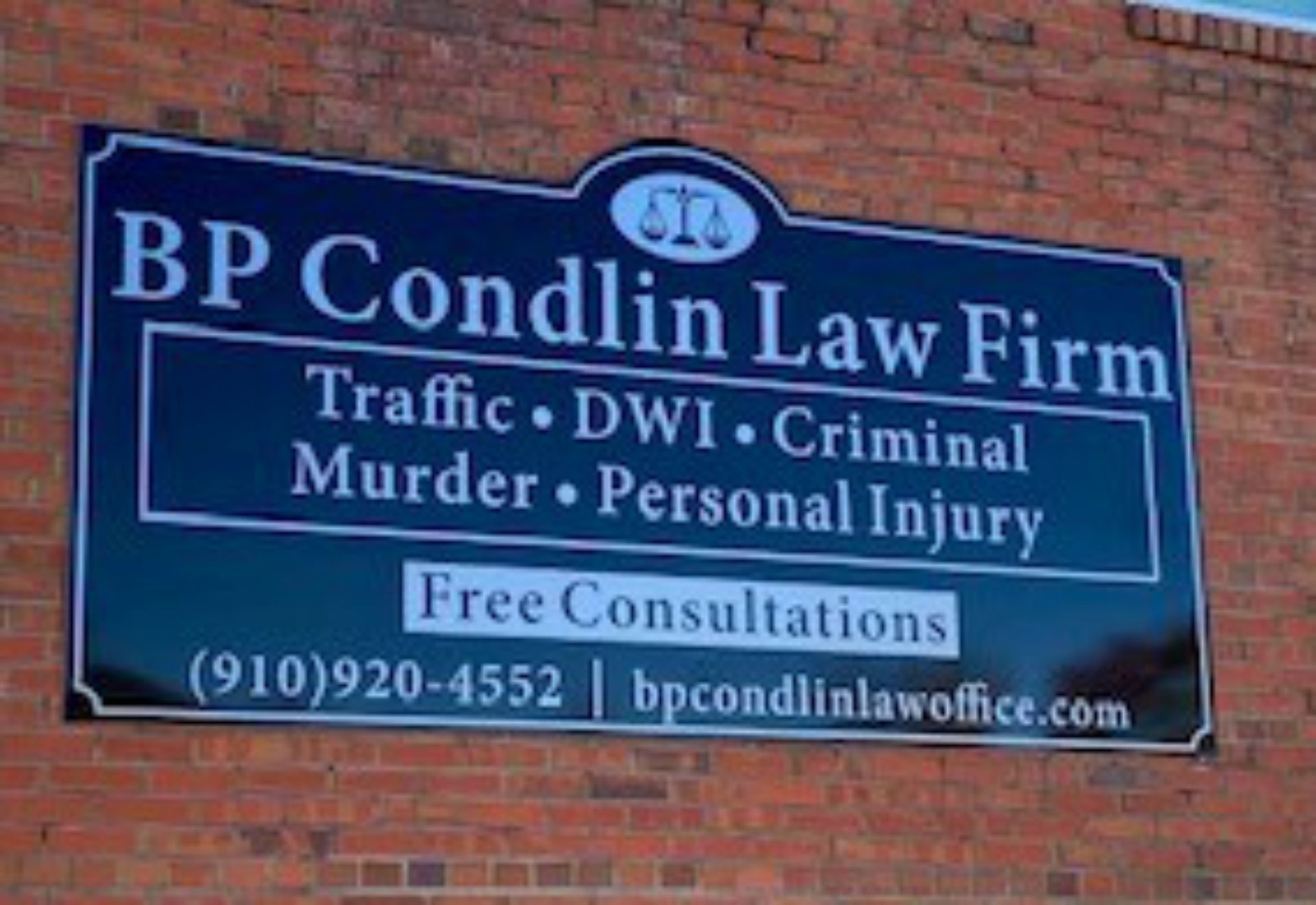 A bp condin law firm sign on a brick wall