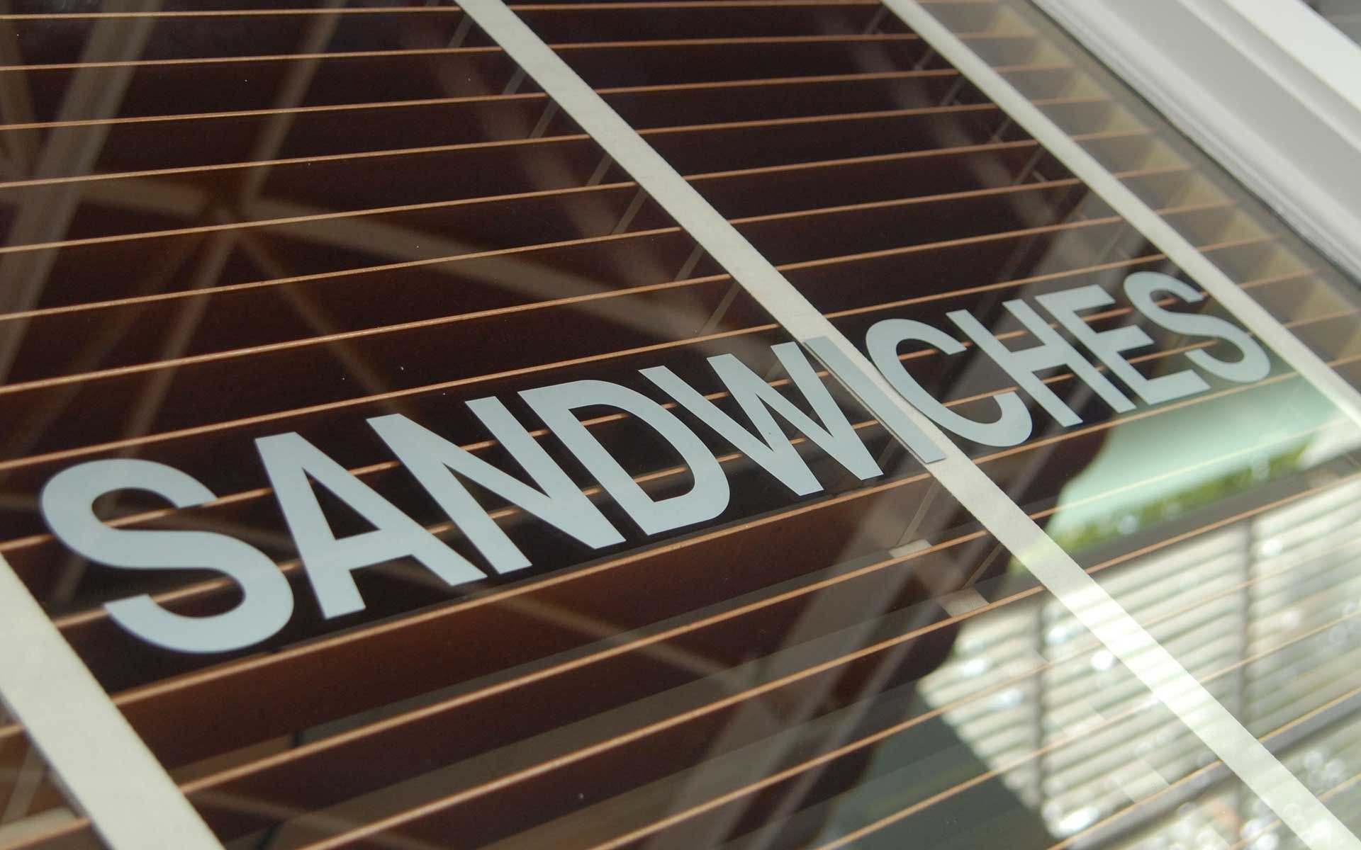 The word sandwiches that is on a window
