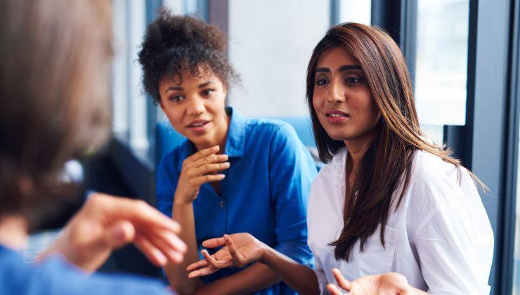 The women interact during an office meeting