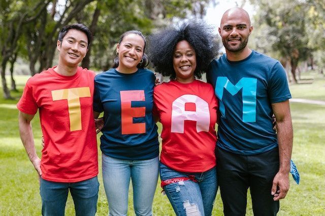 4 people wearing tee shirts, each with a letter of the word team