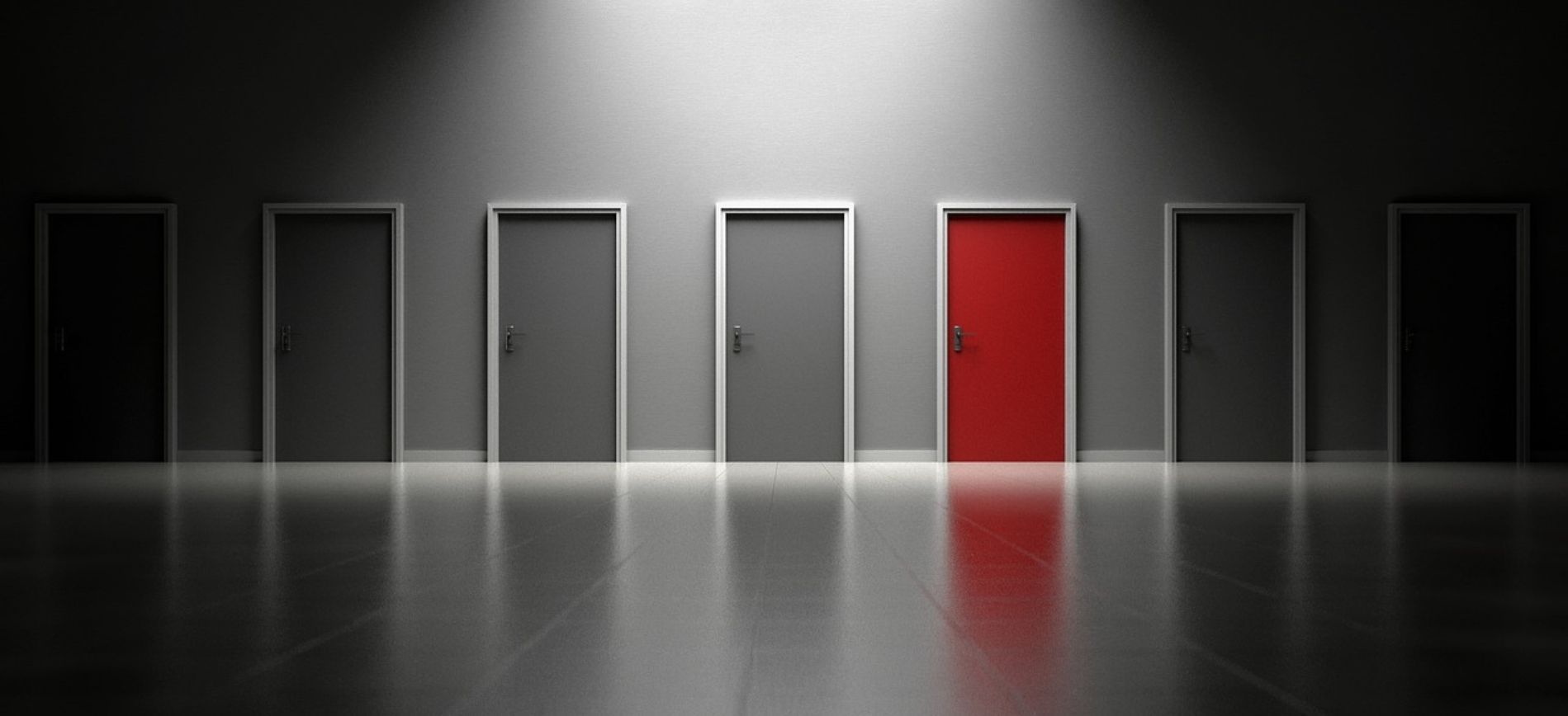 An image of a row of doors in black and white with one red door