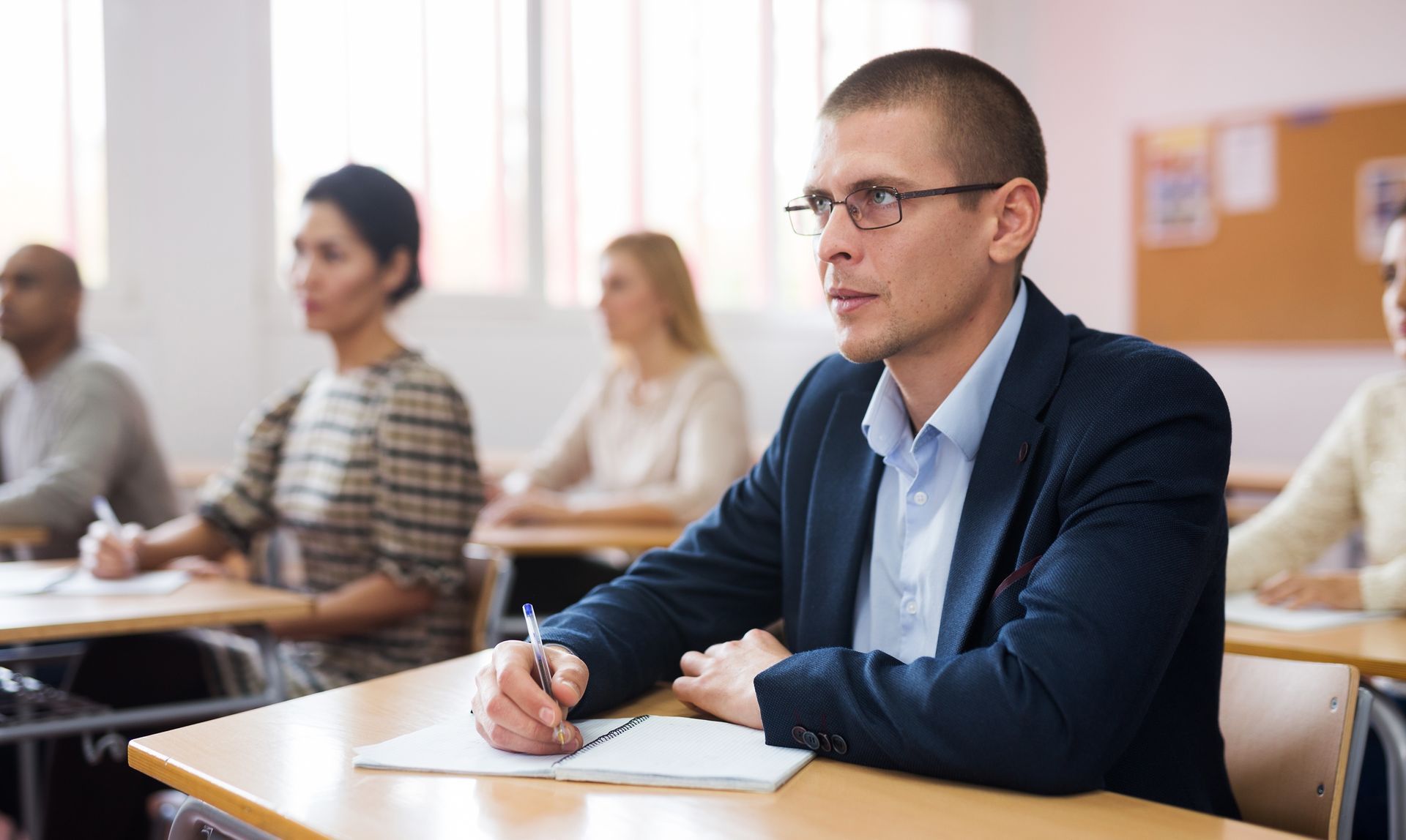 Diverse individuals sitting in a classroom