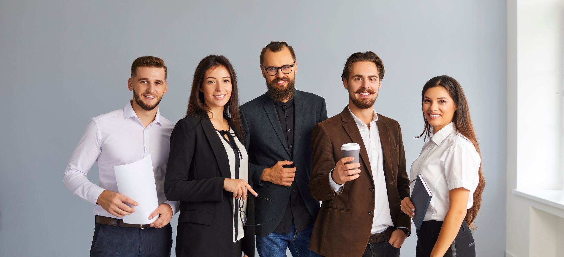 A group of coworkers smiles at the camera