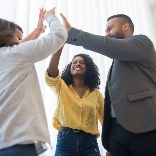 team high 5 focus on young Black woman in yellow blouse