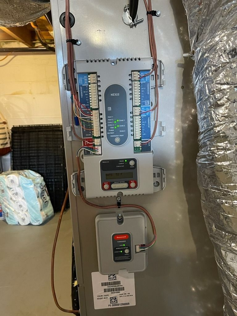 Electrical panel with meters and wiring mounted on a metallic wall, in a utility area