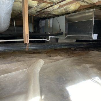 Attic crawlspace with HVAC ductwork, insulation, and exposed beams