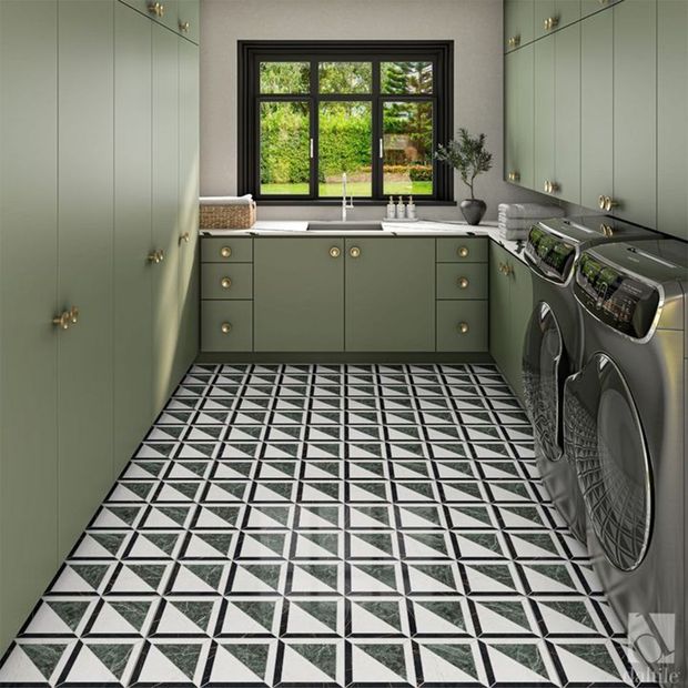 Laundry room with green cabinets, patterned floor, and window.